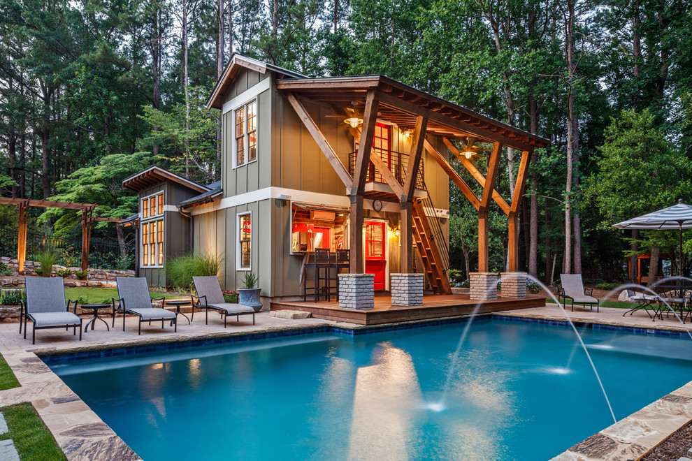 This is an example of a country backyard rectangular pool in Atlanta with a pool house.