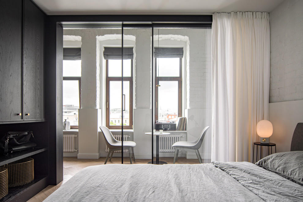 Design ideas for a contemporary bedroom in Moscow with white walls and light hardwood floors.