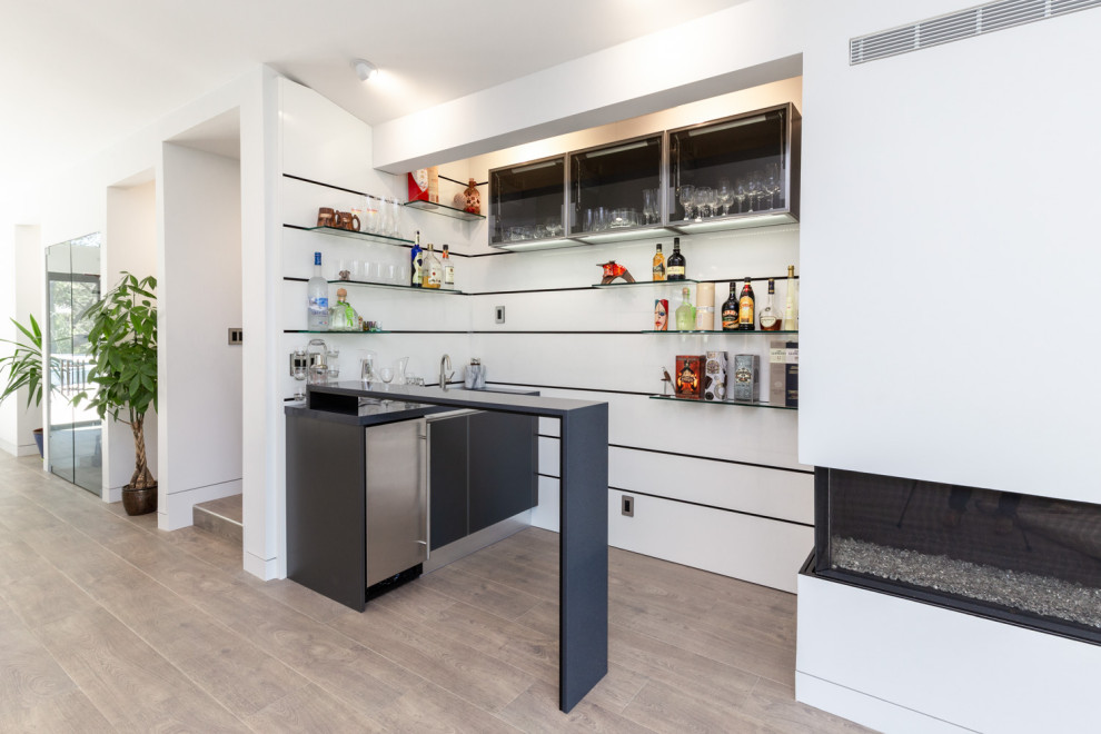 Design ideas for a mid-sized modern galley wet bar in San Francisco with flat-panel cabinets, black cabinets, quartz benchtops and black benchtop.