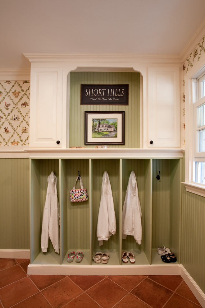 Design ideas for a traditional mudroom in New York with green walls and terra-cotta floors.