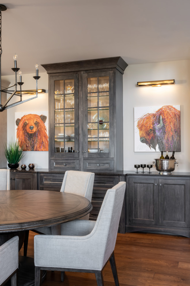 Cette image montre une salle à manger sud-ouest américain avec un mur gris, un sol en bois brun et un sol marron.