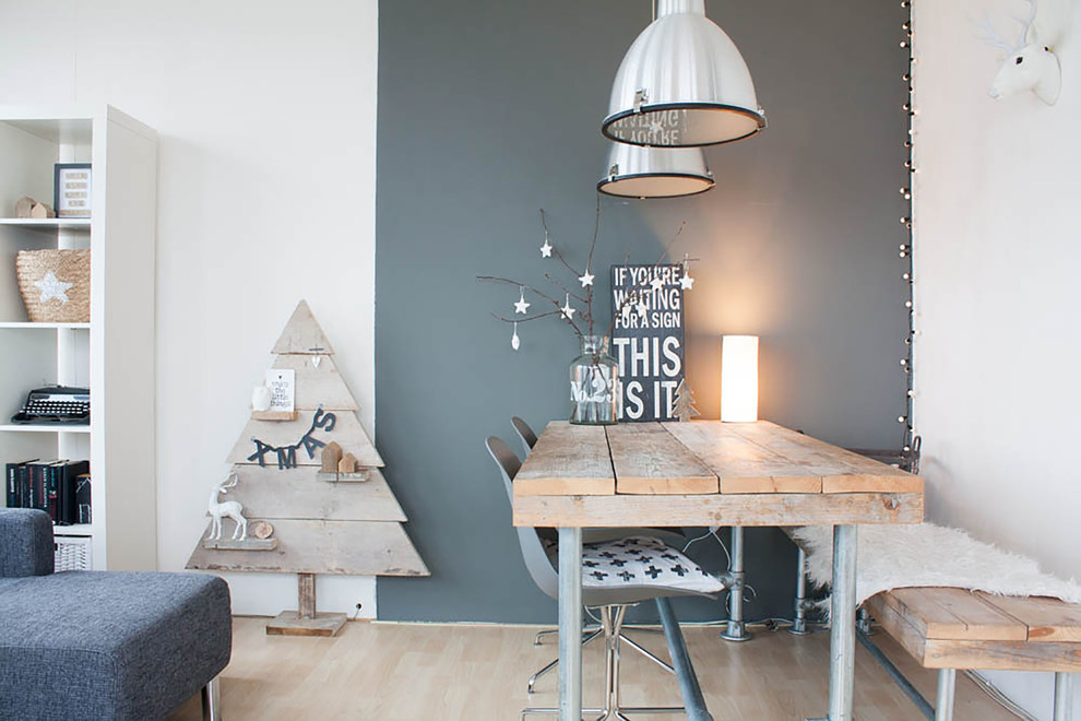 This is an example of a scandinavian dining room in Amsterdam with light hardwood floors and grey walls.