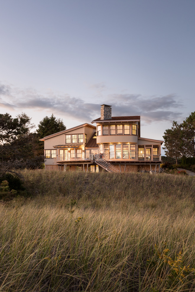 This is an example of a beach style three-storey beige exterior in Portland Maine with mixed siding.