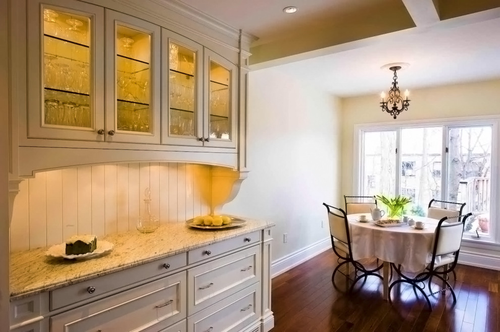 Cette image montre une petite salle à manger traditionnelle avec une banquette d'angle, un mur beige, parquet foncé et un sol marron.
