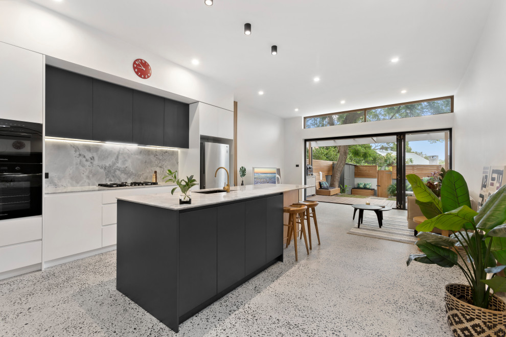 シドニーにある北欧スタイルのおしゃれなアイランドキッチン (大理石カウンター、大理石のキッチンパネル、コンクリートの床) の写真