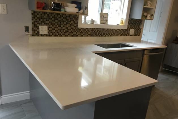 Small transitional kitchen photo with quartz countertops, stainless steel appliances and white countertops