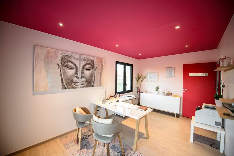 Mid-sized asian study room in Toulouse with red walls, laminate floors, a freestanding desk and beige floor.