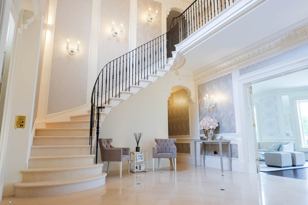 На фото: изогнутая лестница в классическом стиле с ступенями из известняка, подступенками из известняка и деревянными перилами с