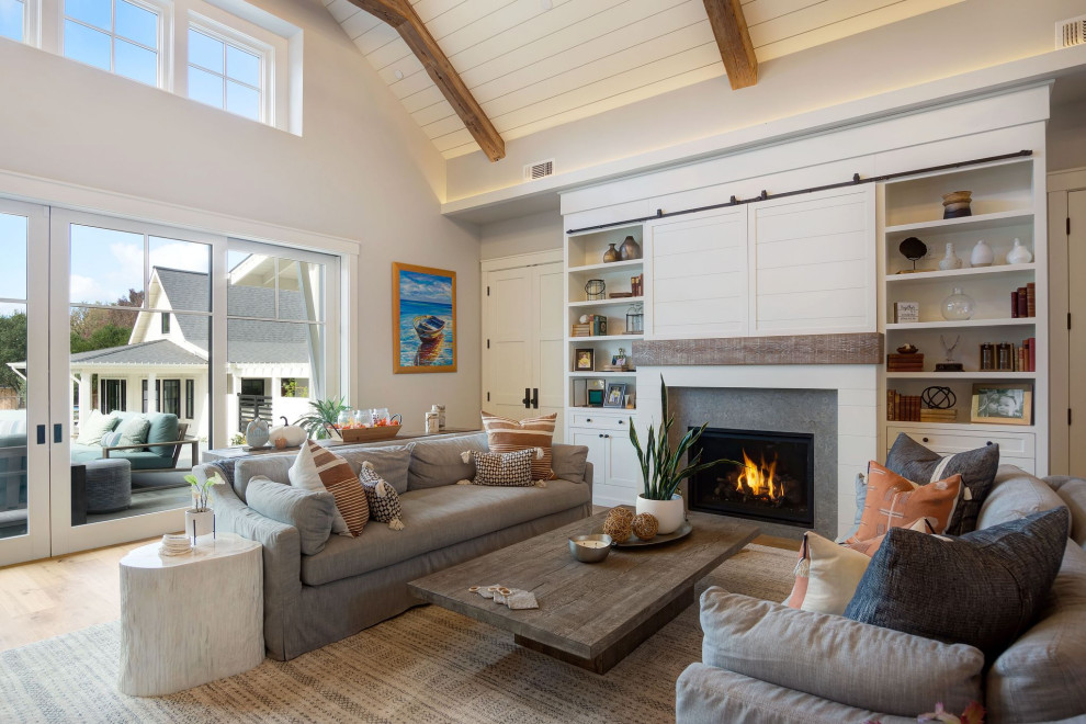 Photo of a country living room in San Francisco with grey walls, medium hardwood floors, a standard fireplace, brown floor, exposed beam, timber and vaulted.