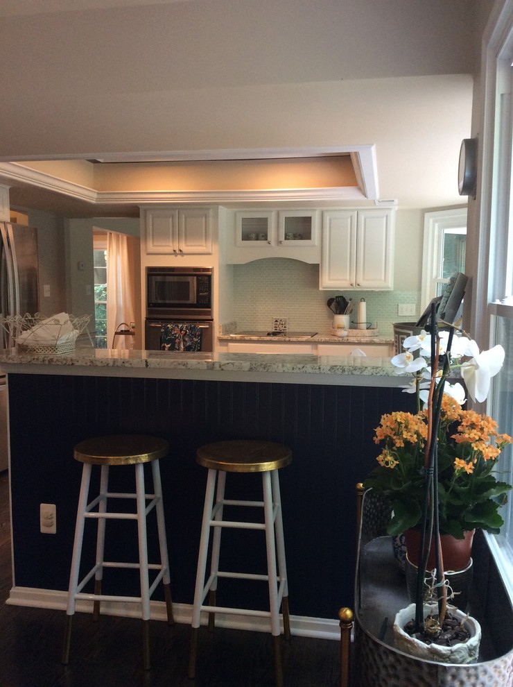 Mid-sized transitional u-shaped dark wood floor and brown floor eat-in kitchen photo in DC Metro with raised-panel cabinets, white cabinets, stainless steel appliances, an island, white countertops, blue backsplash and glass sheet backsplash