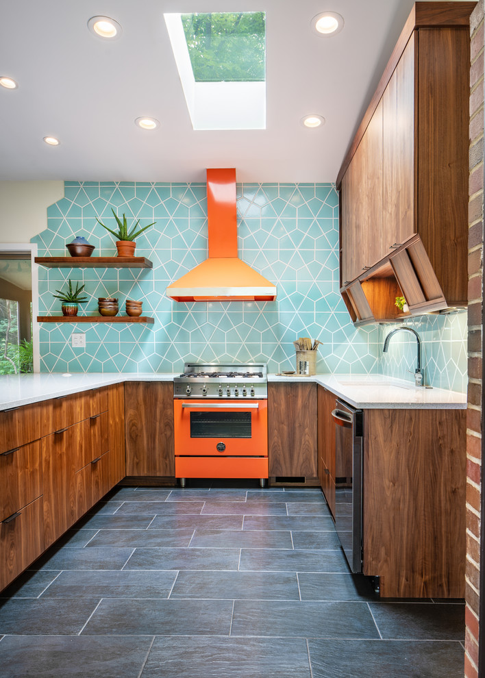 Example of a mid-sized 1960s u-shaped ceramic tile and black floor kitchen design in Cincinnati with flat-panel cabinets, quartz countertops, ceramic backsplash, colored appliances, dark wood cabinets, blue backsplash, an undermount sink, a peninsula and white countertops