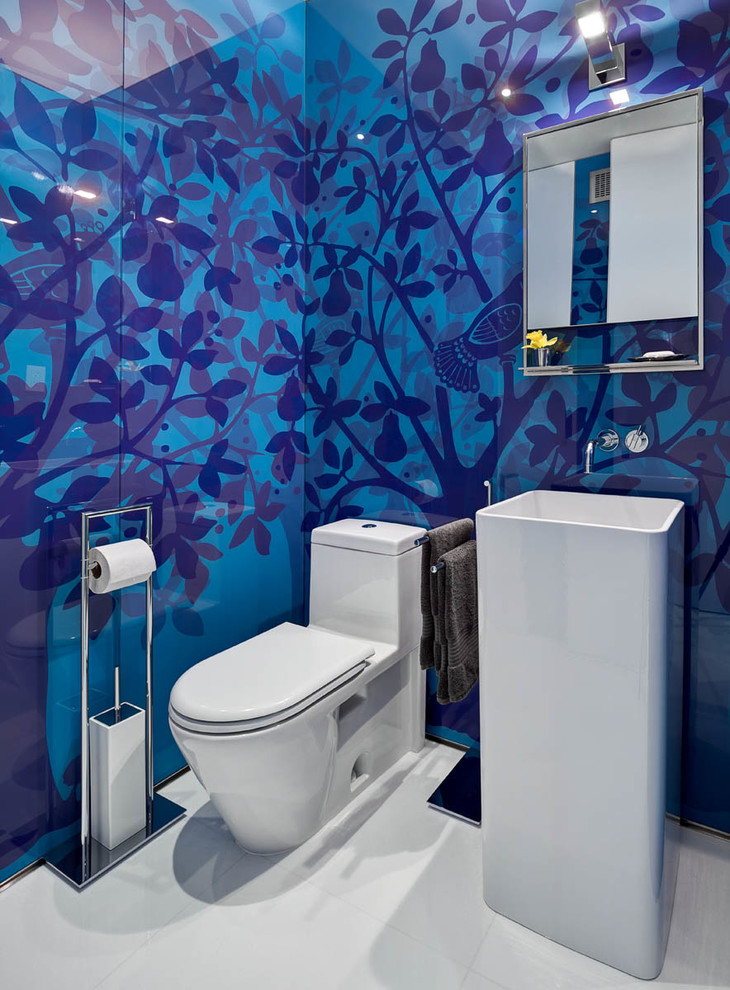 Photo of a mid-sized contemporary powder room in New York with a pedestal sink, a one-piece toilet, blue walls, porcelain floors and white floor.