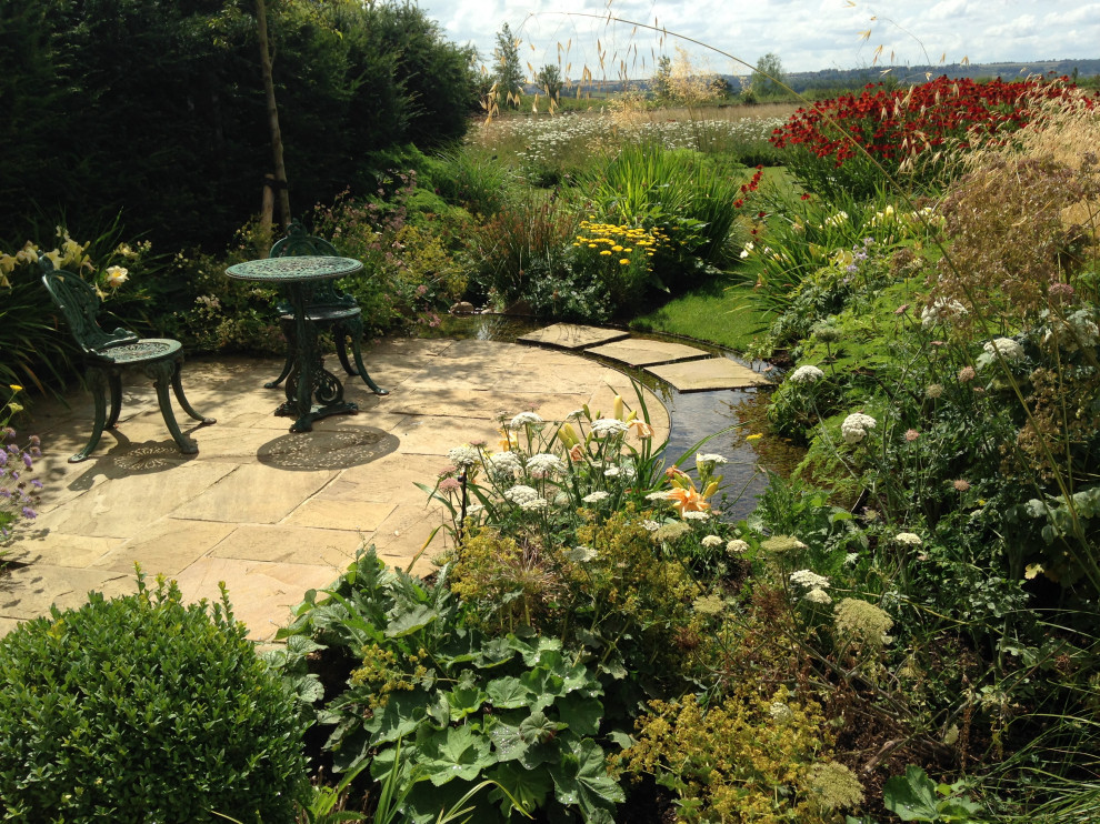 Photo of an expansive traditional garden in Gloucestershire with river rock.
