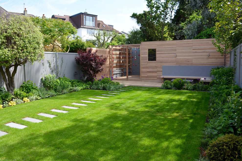 Photo of a mid-sized contemporary backyard full sun garden in London with decking.