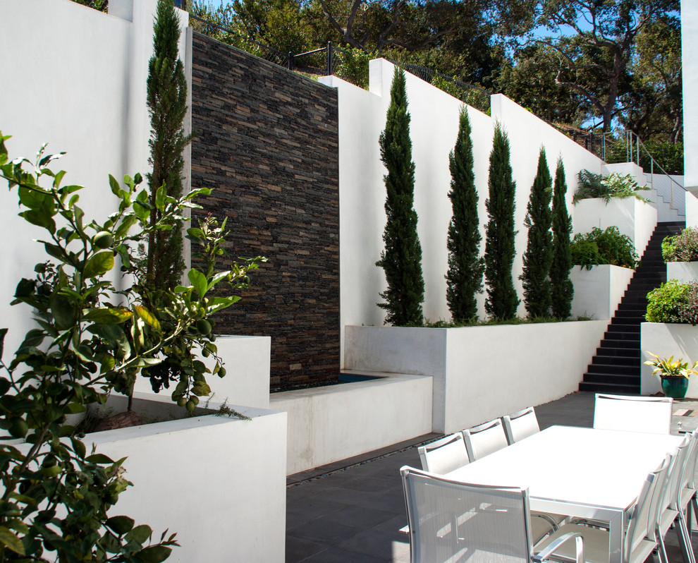 Photo of a mid-sized southwestern shade backyard concrete paver water fountain landscape in Santa Barbara for spring.