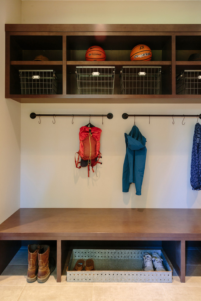 Large mountain style porcelain tile mudroom photo in Seattle with beige walls and a medium wood front door