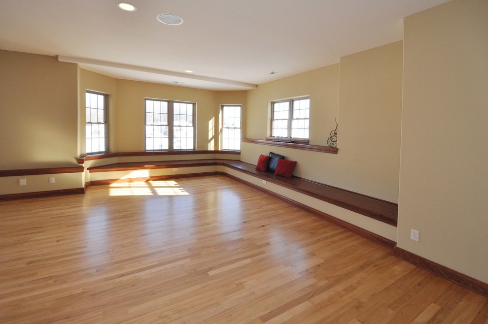 Inspiration for an expansive transitional look-out basement in Milwaukee with beige walls and medium hardwood floors.
