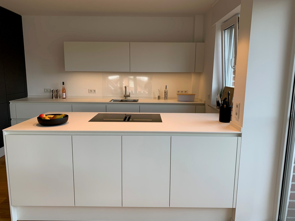Photo of a mid-sized modern kitchen in Other with with island and white benchtop.