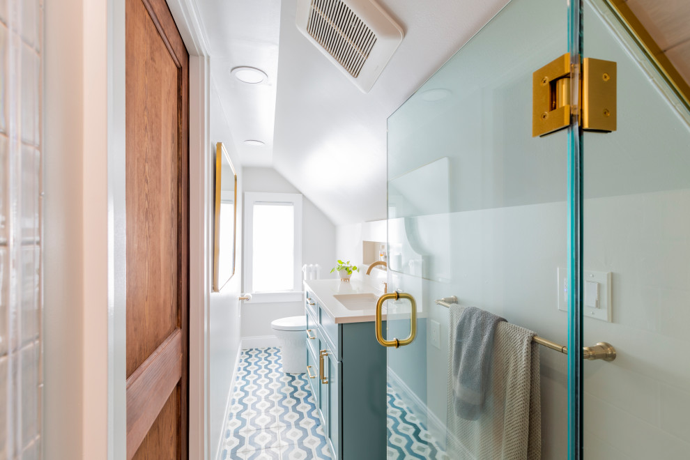 Photo of a small transitional master bathroom in New York with shaker cabinets, blue cabinets, an alcove shower, a two-piece toilet, blue tile, subway tile, cement tiles, an undermount sink, engineered quartz benchtops, blue floor, a hinged shower door, white benchtops, a niche, a single vanity and a built-in vanity.