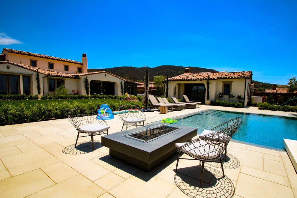 This is an example of a large contemporary back rectangular infinity swimming pool in San Diego with with pool landscaping and tiled flooring.