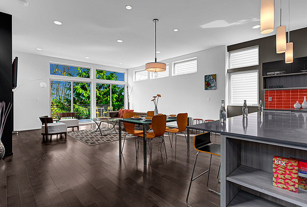 This is an example of a mid-sized modern open plan dining in Portland with white walls, dark hardwood floors and brown floor.