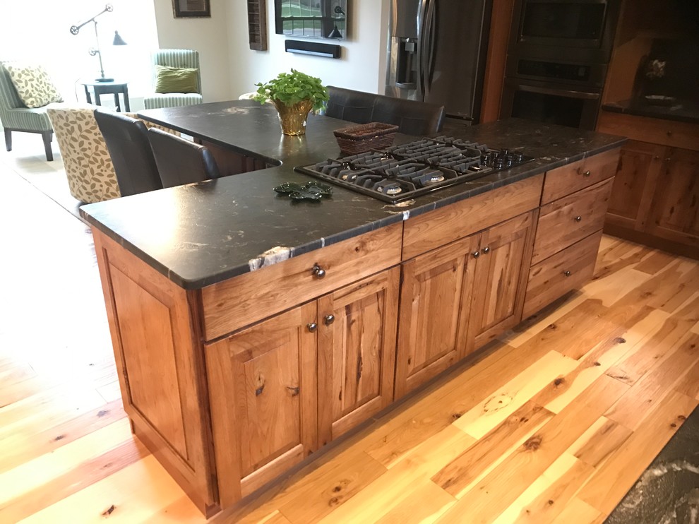 Mid-sized mountain style l-shaped eat-in kitchen photo with an undermount sink, raised-panel cabinets, medium tone wood cabinets, granite countertops and an island