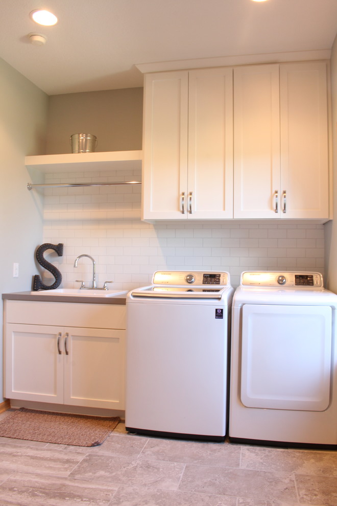 Inspiration for a mid-sized traditional u-shaped utility room in Minneapolis with a drop-in sink, recessed-panel cabinets, white cabinets, laminate benchtops, grey walls, ceramic floors and a side-by-side washer and dryer.