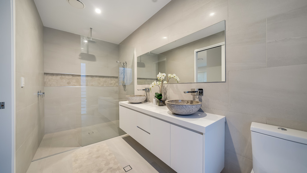 Contemporary 3/4 bathroom in Brisbane with flat-panel cabinets, white cabinets, a curbless shower, a one-piece toilet, beige tile, beige walls, a vessel sink, beige floor, an open shower and white benchtops.
