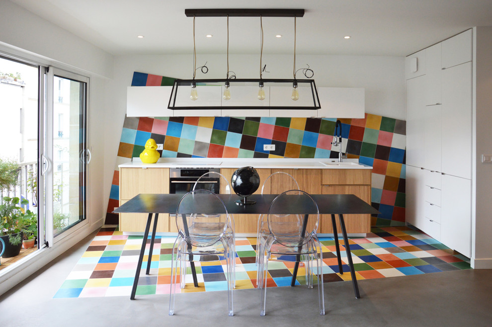 Photo of a small contemporary single-wall kitchen in Paris with multi-coloured splashback, cement tile splashback, a drop-in sink, flat-panel cabinets, medium wood cabinets, concrete floors, no island and stainless steel benchtops.