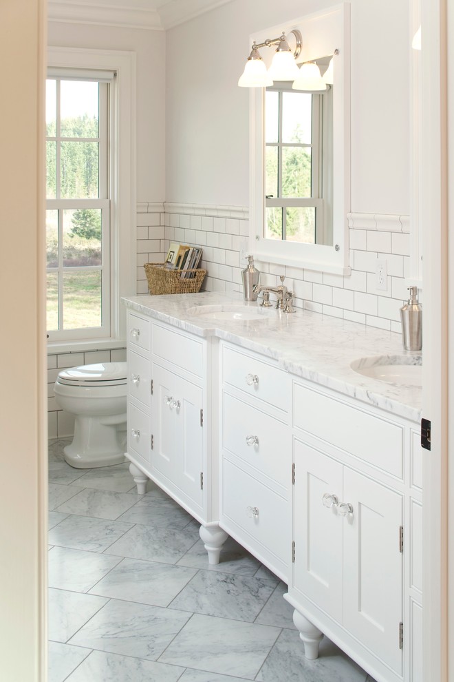 Photo of a mid-sized traditional master bathroom in Seattle with an undermount sink, white cabinets, white tile, subway tile, white walls, marble benchtops, ceramic floors, white benchtops and beaded inset cabinets.