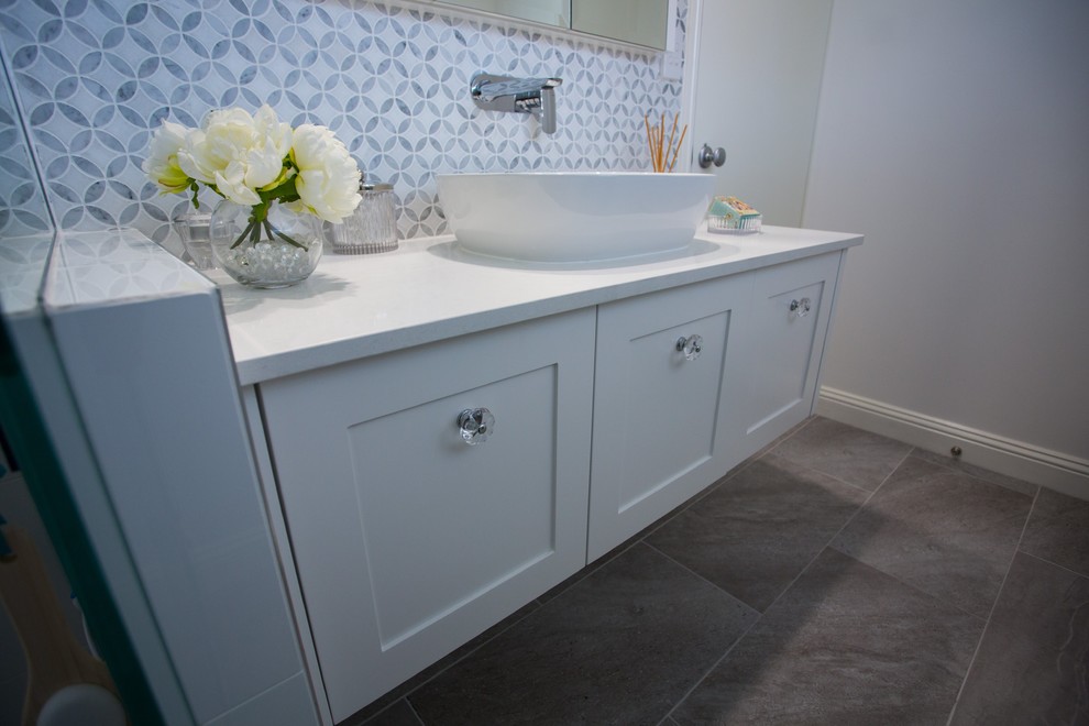 Inspiration for a small traditional 3/4 bathroom in Brisbane with shaker cabinets, white cabinets, an open shower, gray tile, ceramic tile, white walls, ceramic floors, a vessel sink, engineered quartz benchtops, grey floor and white benchtops.