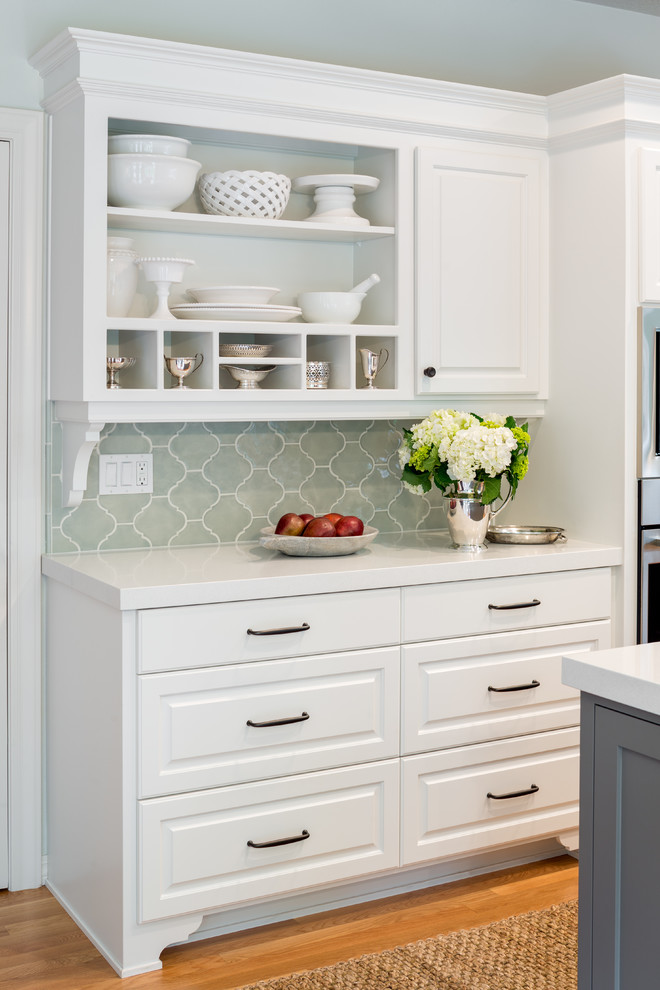 Open concept kitchen - mid-sized transitional u-shaped light wood floor and beige floor open concept kitchen idea in Portland with an undermount sink, raised-panel cabinets, white cabinets, quartzite countertops, gray backsplash, ceramic backsplash, stainless steel appliances and an island