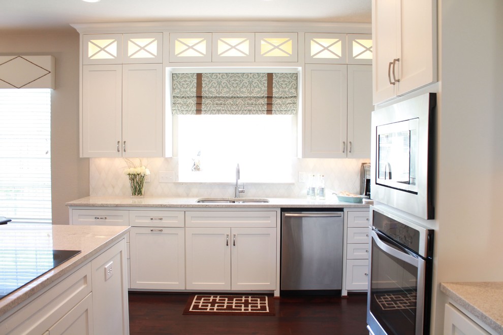 Inspiration for a large traditional l-shaped eat-in kitchen in Dallas with shaker cabinets, white cabinets, granite benchtops, white splashback, stainless steel appliances, a drop-in sink, dark hardwood floors and with island.