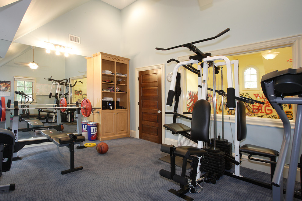 This is an example of an expansive contemporary home weight room in New York with blue walls, carpet, blue floor and vaulted.