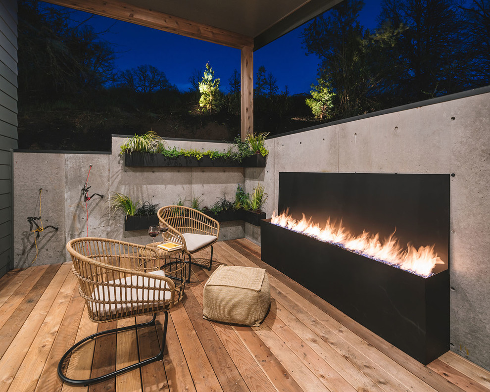 Design ideas for a country deck in Portland with a roof extension and with fireplace.