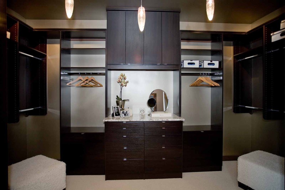 Photo of a mid-sized contemporary gender-neutral dressing room in Portland with flat-panel cabinets, brown cabinets, carpet and beige floor.