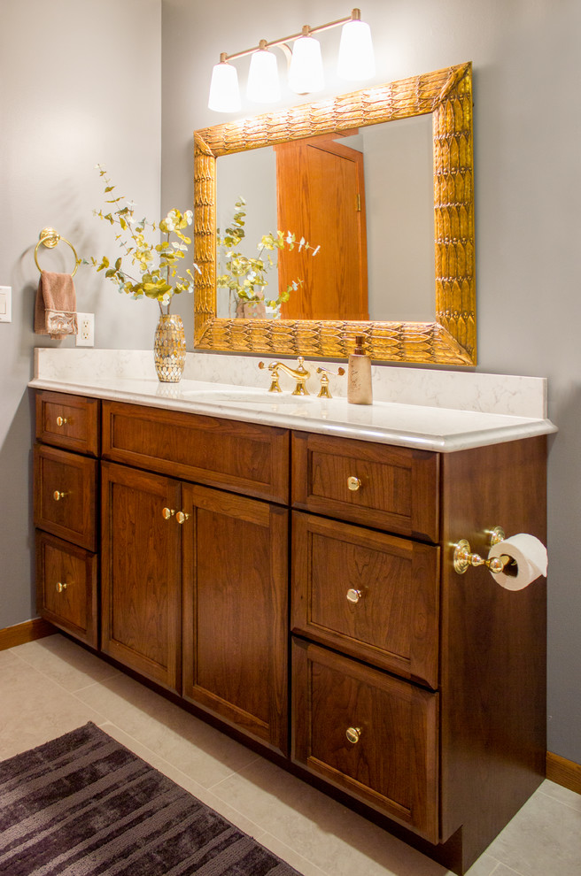 Inspiration for a transitional single-sink bathroom remodel in Cedar Rapids with raised-panel cabinets, medium tone wood cabinets, quartz countertops, white countertops, a built-in vanity and gray walls