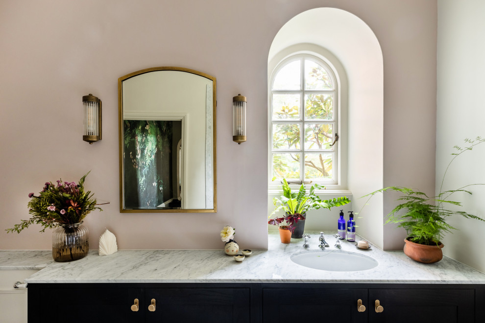 Пример оригинального дизайна: детская ванная комната среднего размера в викторианском стиле с фасадами в стиле шейкер, черными фасадами, ванной на ножках, душем над ванной, инсталляцией, белой плиткой, мраморной плиткой, розовыми стенами, мраморным полом, врезной раковиной, мраморной столешницей, разноцветным полом, открытым душем, белой столешницей, нишей, тумбой под одну раковину и встроенной тумбой