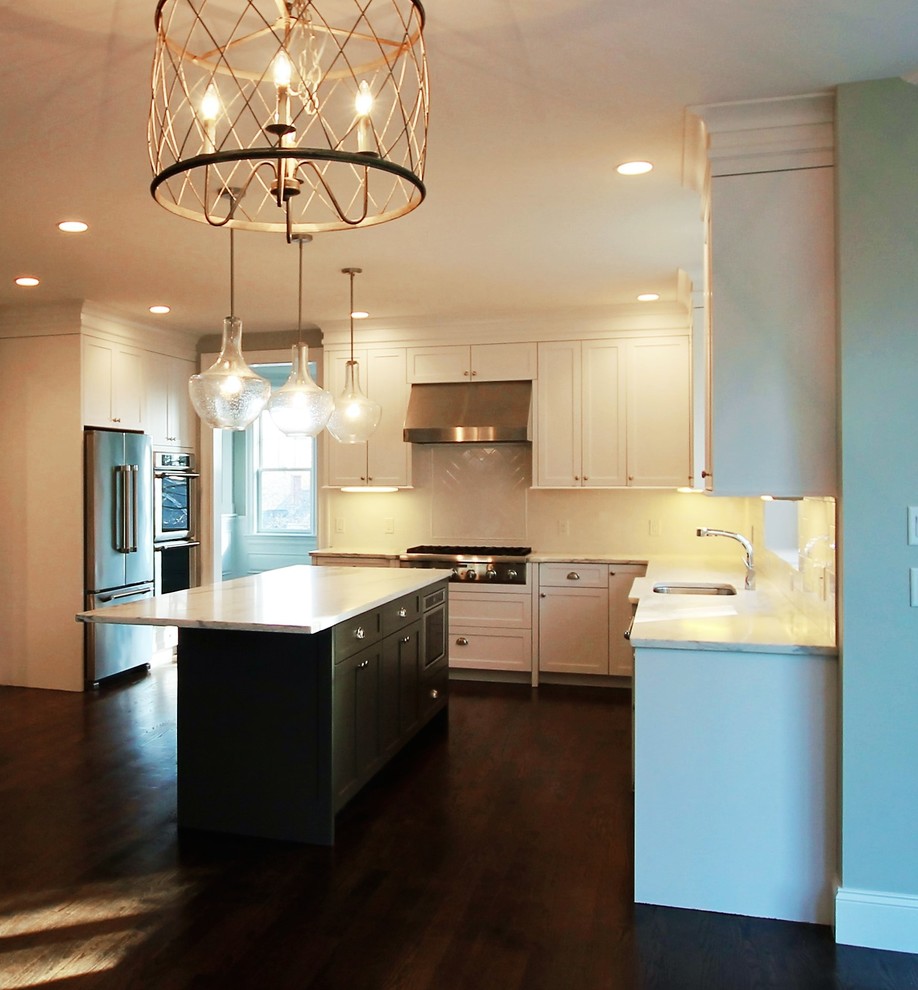 Example of a mid-sized transitional u-shaped dark wood floor and brown floor eat-in kitchen design in Boston with an undermount sink, shaker cabinets, white cabinets, marble countertops, white backsplash, porcelain backsplash, stainless steel appliances and an island