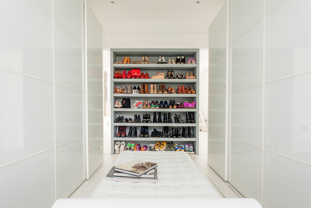 Large contemporary women's walk-in wardrobe in Oxfordshire with flat-panel cabinets, white cabinets and white floor.