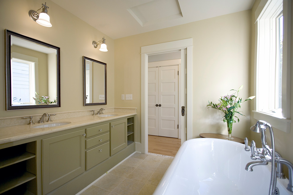 Design ideas for a large traditional master bathroom in Portland with recessed-panel cabinets, green cabinets, a freestanding tub, yellow walls, travertine floors, an undermount sink, marble benchtops and beige floor.