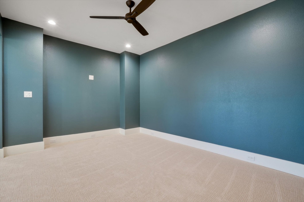 Photo of a mid-sized transitional open concept home theatre in Dallas with blue walls, carpet, a wall-mounted tv and beige floor.
