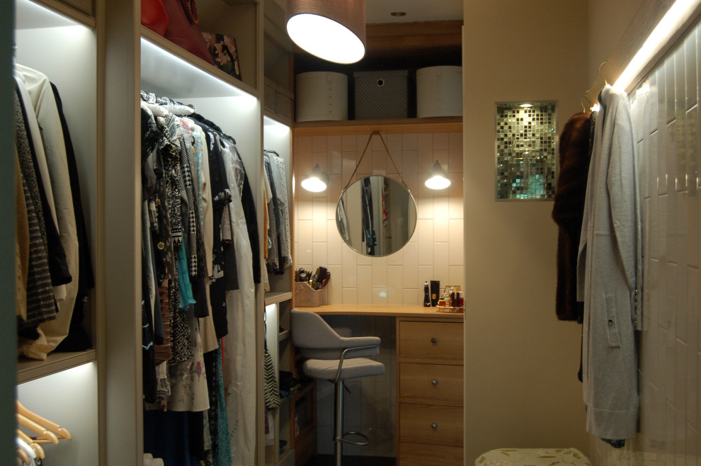 Réalisation d'un petit dressing room design pour une femme avec un placard sans porte, des portes de placard grises, parquet foncé et un sol marron.