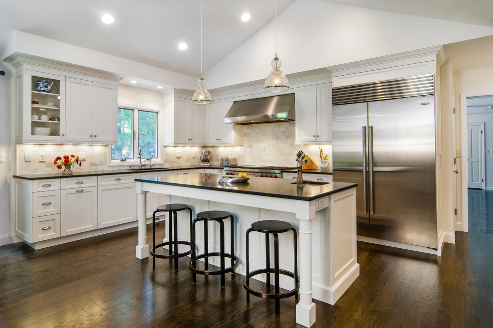 Eat-in kitchen - large transitional l-shaped dark wood floor eat-in kitchen idea with white cabinets, granite countertops, subway tile backsplash, stainless steel appliances, an island, shaker cabinets and beige backsplash