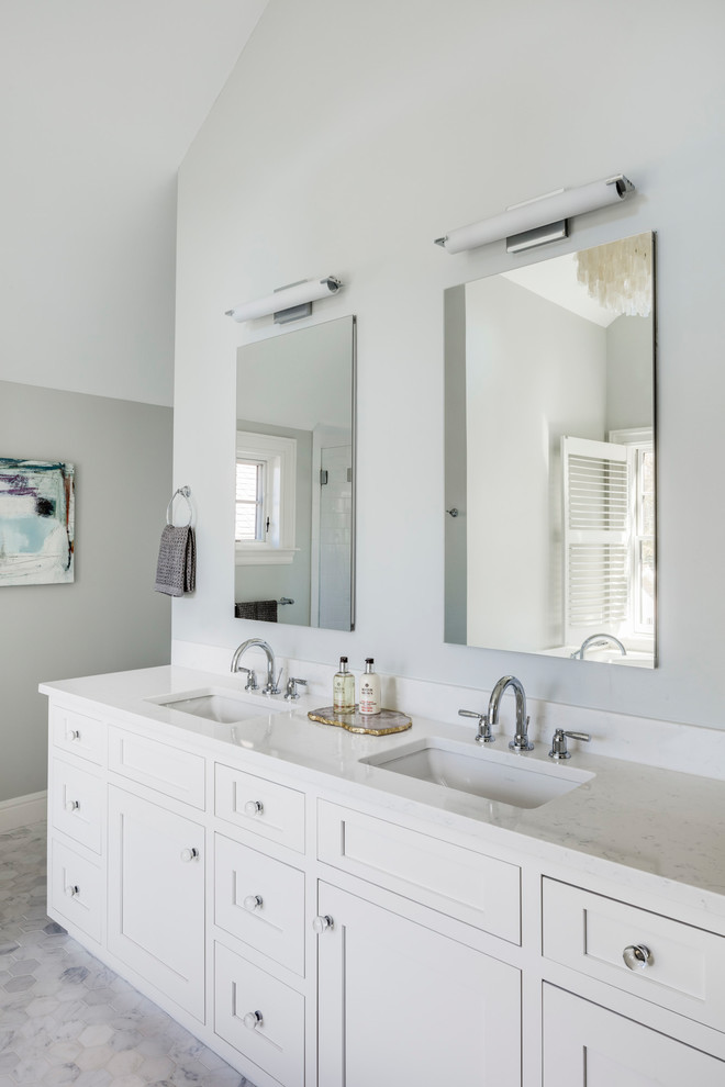 Mid-sized transitional master bathroom in Boston with recessed-panel cabinets, white cabinets, a drop-in tub, an alcove shower, a one-piece toilet, white tile, grey walls, ceramic floors, a console sink, marble benchtops, white floor and a hinged shower door.
