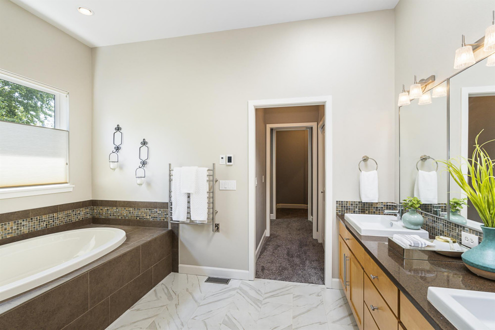 Photo of a large modern master bathroom in Seattle with light wood cabinets, a drop-in tub, a curbless shower, a one-piece toilet, multi-coloured tile, glass sheet wall, beige walls, ceramic floors, an integrated sink, granite benchtops, a hinged shower door and brown benchtops.