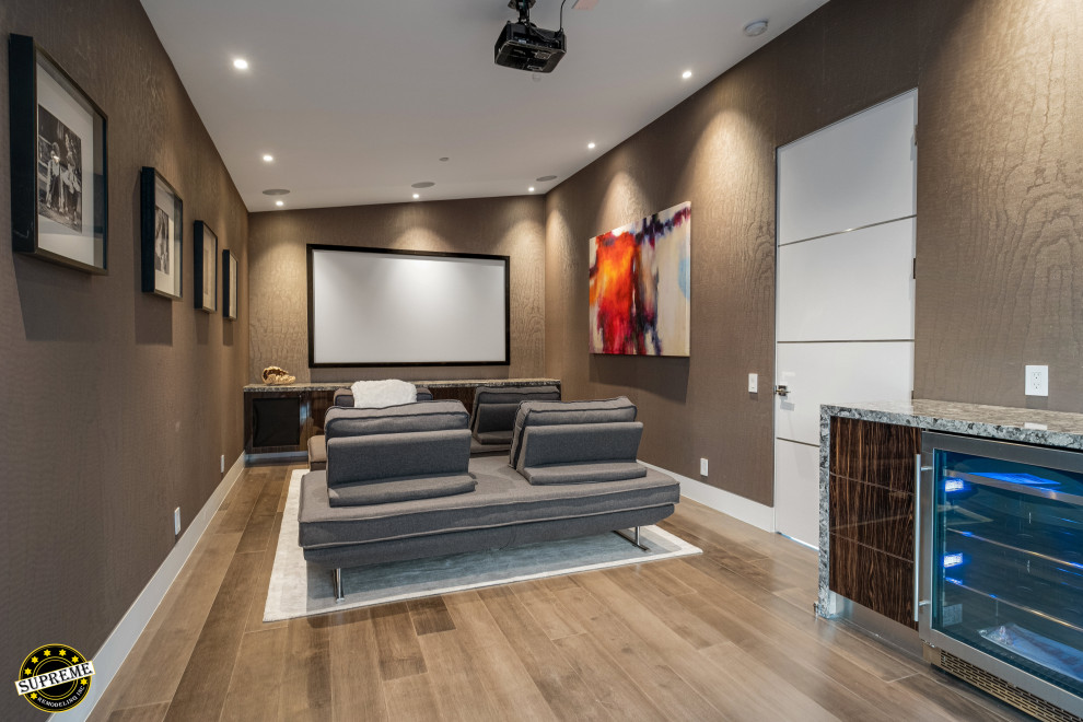 Mid-sized modern enclosed home theatre in Los Angeles with beige walls, light hardwood floors, a projector screen and beige floor.