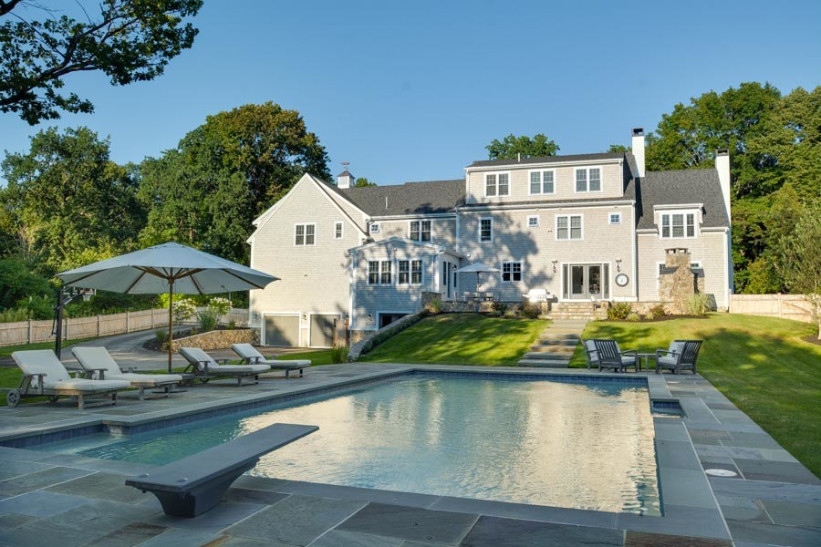 Inspiration for a large transitional backyard rectangular lap pool in Boston with natural stone pavers.