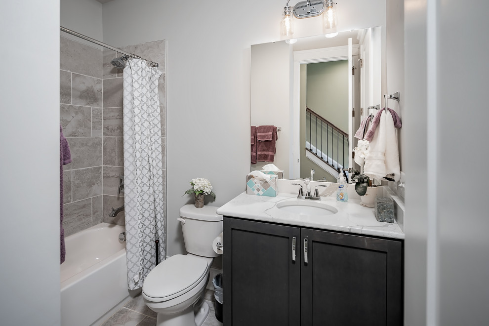 This is an example of a small bathroom in Charlotte with recessed-panel cabinets, black cabinets, a shower/bathtub combo, wood-look tile, engineered quartz benchtops, a shower curtain, a single vanity and a built-in vanity.