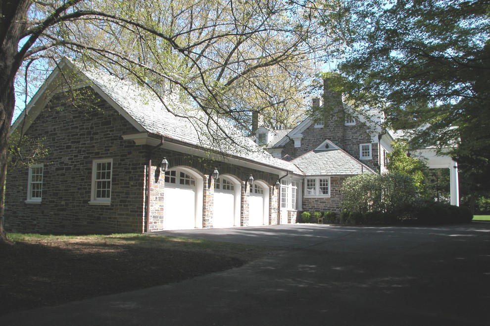 Inspiration for an expansive traditional three-car garage in Other.